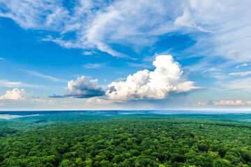 beautiful clouds in the blue sky over a green forest. panoramic view, drone shooting. green valley. Aerial view landscape.