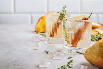 Festive summer spicy cocktail with pears and thyme on light beige background.