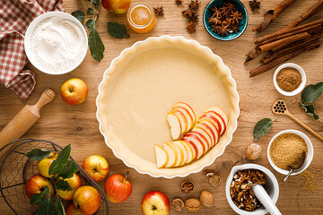 Cooking Thanksgiving autumn apple pie with fresh fruits and walnuts on wooden table, top view