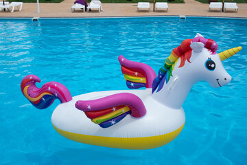 Inflatable unicorn in pool. Pool party, summer holidays, beach vacation. Fantasy swim ring for...