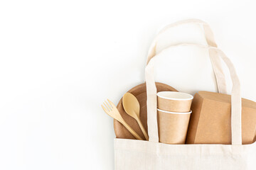 Biodegradable cardboard eco tableware in a shopping bag on a white background. Ecology concept, recyclable materials, environmental protection. Food delivery, takeaway. Mock up, copy space.
