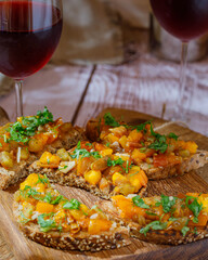 Bruschetta with olive tapenade and fresh tomatoes on cutting board. Wooden background. Close up.