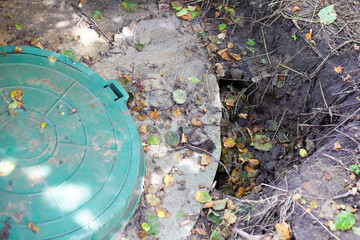 Collapsed soil near the concrete rings of an underground well. Installed septic tank, poor soil compaction