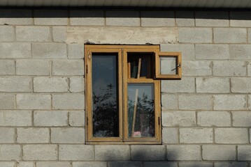 one brown old wooden window on a gray brick wall of a building