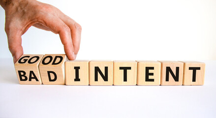 Good or bad intent symbol. Businessman turns wooden cubes and changes words 'bad intent' to 'good...