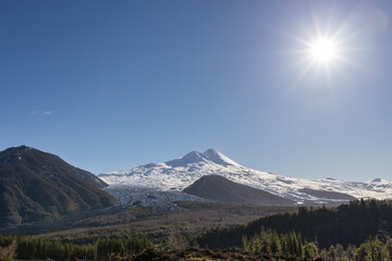 Beautiful landscape of a snowy volcano and the sun of the afternoon making a backlighting effect