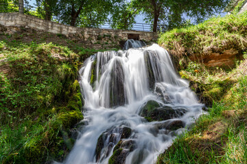 Waterfalls from the Cifuentes river as it passes through the town of Trillo. Wild river. Urban waterfalls.