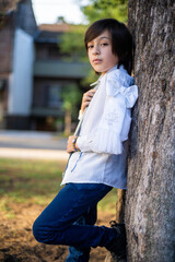portrait of a boy adjusting his tie, dressed for his first communion.