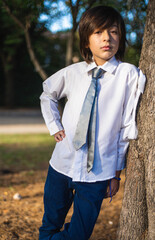 child in communion clothes at the park.