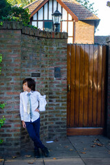 portrait of a child dressed for his first communion at the entrance of his home