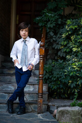 child in communion clothes at the entrance of his house 