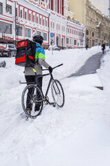Delivery man with bicycle working at winter, city street