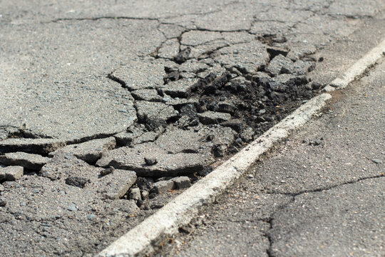 Broken asphalt. It's a bad road. Pits on the road in Russia.