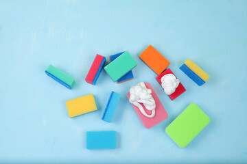 Colored sponges for washing dishes and cleaning in a sunny room. The concept of cleanliness in the house, protection from germs and viruses, daily cleaning in the house, advertising for a store