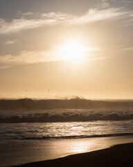 Vertical view of sunset on the beach in front of the sun