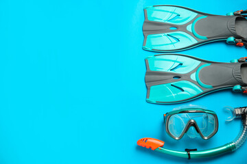 Pair of turquoise flippers and mask on light blue background , flat lay. Space for text