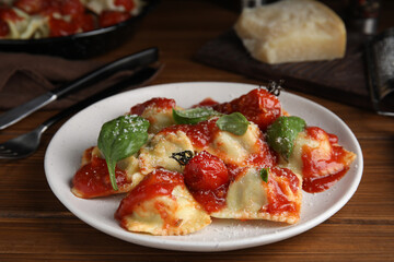 Tasty ravioli with tomato sauce served on wooden table