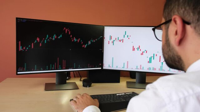  A man with glasses is watching the cryptocurrency exchange on the computer