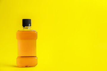 Mouthwash on yellow background, space for text