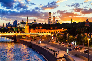 View of the Moscow Kremlin and Moscow City Skyscrapers along the quay of the Moscow river during evening sunset blue hour