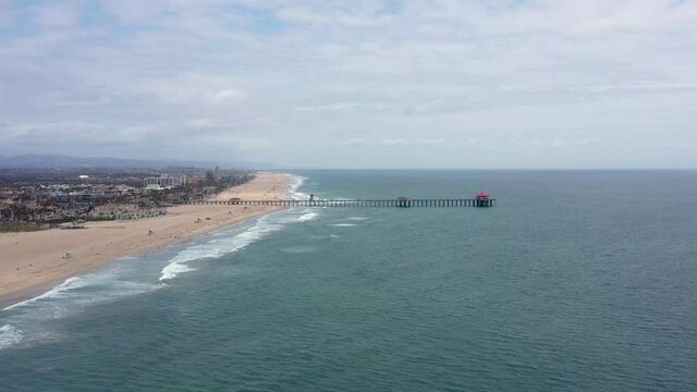 Aerial drone view of Huntington Beach Pier coastline with Pacific Ocean waves rolling along beach_01