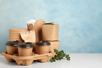 Disposable eco friendly products on white wooden table. Space for text