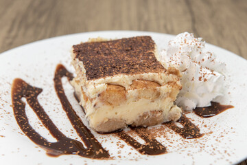 Sweet dessert on a decorated plate of tiramisu cake to enjoy after a meal