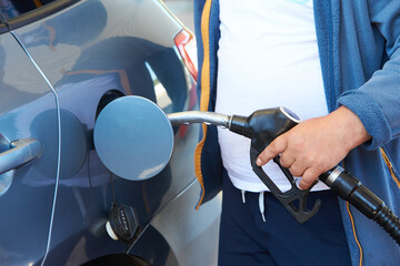 Close up of mans hand refueling a car at a petrol station