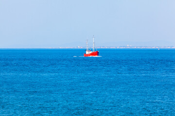 Fototapeta premium Red boat sailing in the North Sea . Ship in the Oresund Bay in Sweden