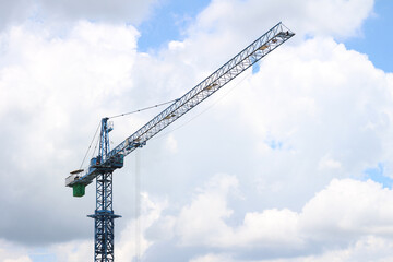 The construction crane on against blue sky.