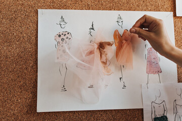 Lady creating dress samples with lace. Woman works as garments designer and adds beautiful details...