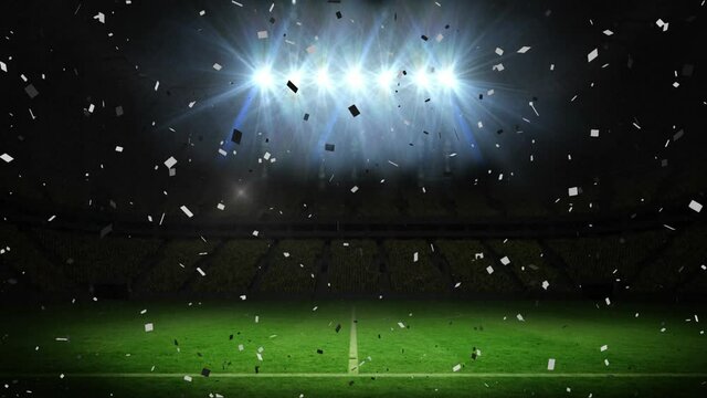 Animation of confetti falling over floodlit pitch at sports stadium at night