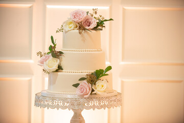 Beautiful Three tier Wedding Cake with pink and white flowers decor and wedding reception
