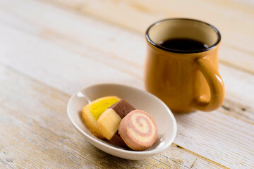 カラフルなクッキーと黄土色のコーヒーカップ