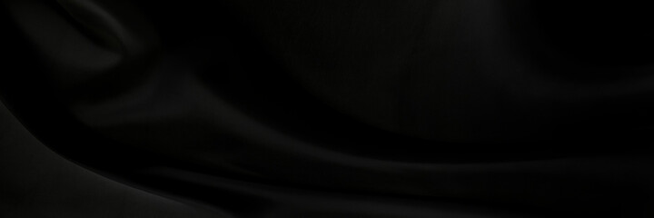Black gray satin dark fabric texture luxurious shiny that is abstract silk cloth panorama background with patterns soft waves blur beautiful.