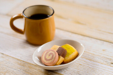 カラフルなクッキーと黄土色のコーヒーカップ