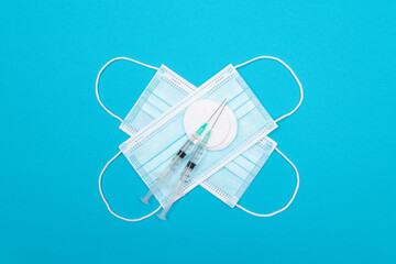 Vaccination, Immunology or Revaccination Concept - Two Medical Syringe and the Medical Mask Lying on Blue Table in Doctor's Office in a Hospital or Clinic