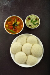 Homemade delicious Indian breakfast dish, steamed rice idly served with coconut chutney and sambar.