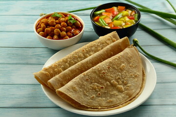 Plate of delicious meal- wheat chapatti served with  chickpeas curry, channa masala- Indian vegetarian breakfast .