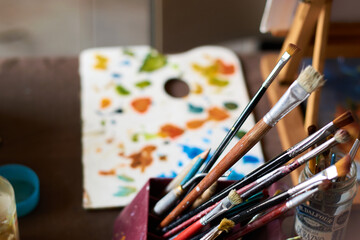 Obraz premium Table with brushes and canvas in an art workshop. Background.