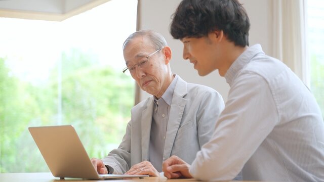 高齢者にパソコンを教える男性