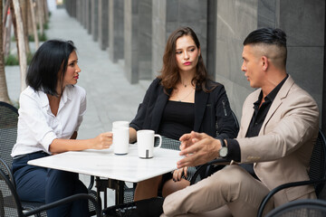  Young Business Group Drinking Coffee and Discussion in Coffee  Shop while Breaking time.