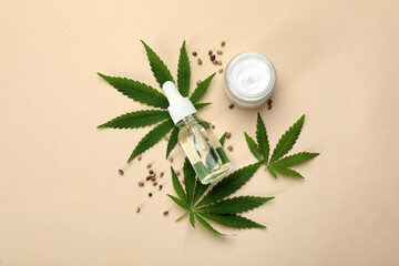 Flat lay composition with CBD oil or THC tincture and hemp leaves on beige background