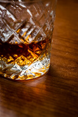 A glass of brandy is on a close-up of the kitchen table.