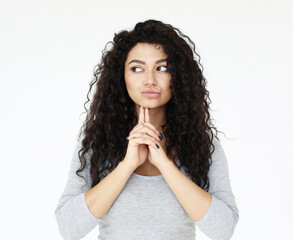 Attractive mixed race female actress wearing grey shirt, standing against white wall during audition