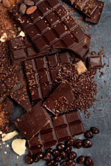 Cacao beans and chocolate on gray background.