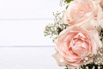 A bouquet of beautiful pink roses on white wooden background.