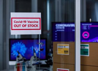 Selective focus on 'out of stock' for Covid 19 vaccines with covid 19 vaccines pack in boxes with separated colours label and microscopes in background . Concept for Covid 19 vaccination