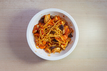 A bowl of chicken spaghetti with tomato sauce.