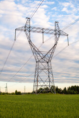 Metal poles electric supports for high-voltage wires in the fields in the summer.High Voltage Poles or Electric tower is transmission high voltage power locate on green field Energy technology concept